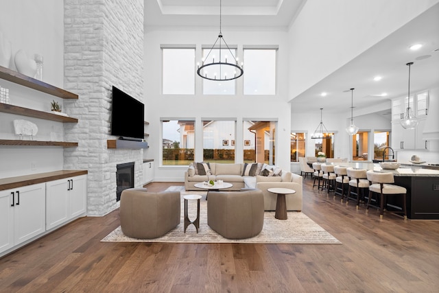 2105 Bennet Ct, Conroe, TX 77384 - living area featuring plenty of natural light, a fireplace, dark wood-style floors, a chandelier, and a towering ceiling