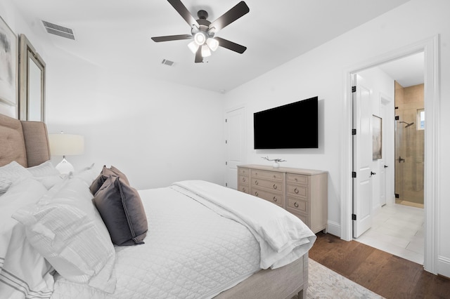 2105 Bennet Ct, Conroe, TX 77384 - bedroom with wood finished floors, a ceiling fan, and ensuite bathroom