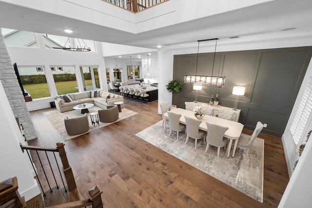 2105 Bennet Ct, Conroe, TX 77384 - dining area with a chandelier, a high ceiling, wood finished floors, plenty of natural light, and a decorative wall