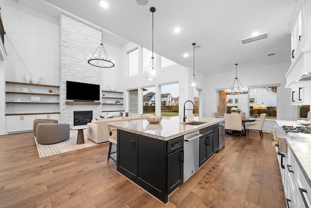 2105 Bennet Ct, Conroe, TX 77384 - kitchen featuring a sink, dark cabinetry, a chandelier, stainless steel dishwasher, and white cabinetry