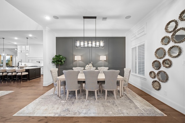 2105 Bennet Ct, Conroe, TX 77384 - dining room with wood finished floors, baseboards, healthy amount of natural light, ornamental molding, and a chandelier