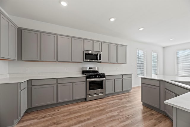 17011 Plover Rock Trl, Hockley, TX 77447 - kitchen featuring gray cabinetry, stainless steel appliances, light wood-type flooring, and recessed lighting