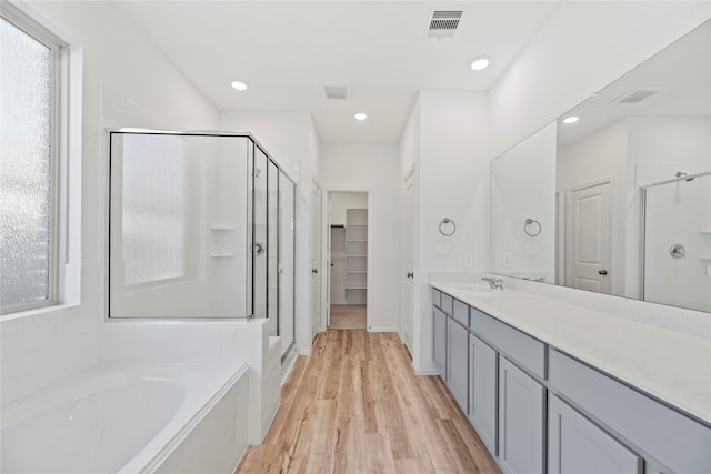 17011 Plover Rock Trl, Hockley, TX 77447 - bathroom featuring a stall shower, vanity, a garden tub, wood finished floors, and a spacious closet