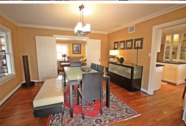 1216 S Shepherd Dr, Houston, TX 77019 - dining room with wood finished floors, ornamental molding, baseboards, and a chandelier