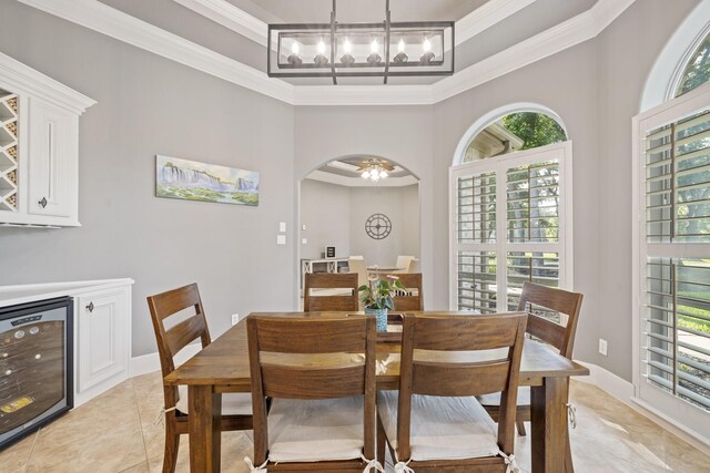 28611 Benders Crossing Dr, Spring, TX 77386 - dining space featuring wine cooler, light tile patterned floors, ornamental molding, a chandelier, and arched walkways