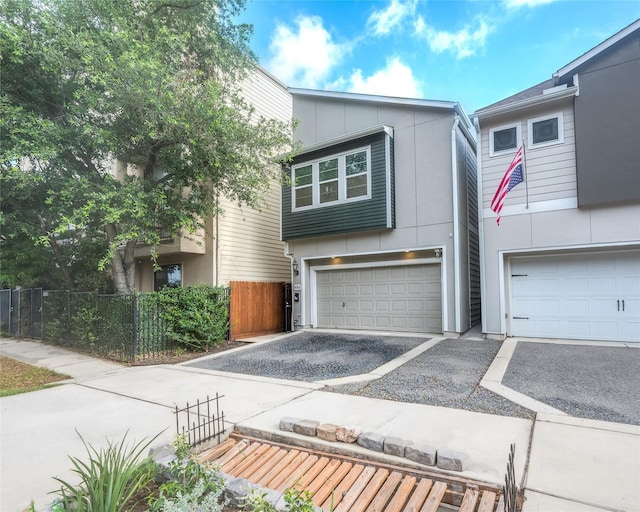 5014 Lillian St, Houston, TX 77007 - view of front facade with an attached garage, asphalt driveway, and stucco siding