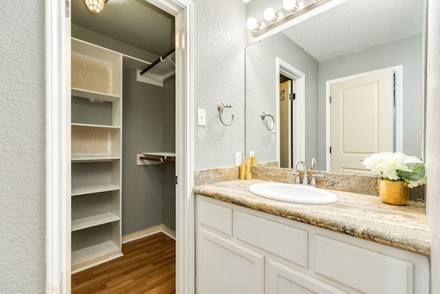 105 Wisteria St, Lake Jackson, TX 77566 - bathroom with wood finished floors, vanity, baseboards, and a closet