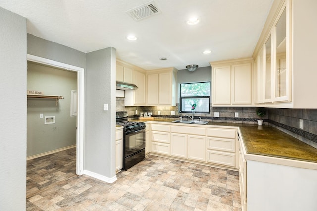 105 Wisteria St, Lake Jackson, TX 77566 - kitchen with black gas range oven, a sink, under cabinet range hood, tasteful backsplash, and dark countertops