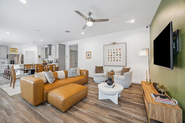 12717 Ermine St, Houston, TX 77047 - living area featuring wood finished floors, ceiling fan, and recessed lighting