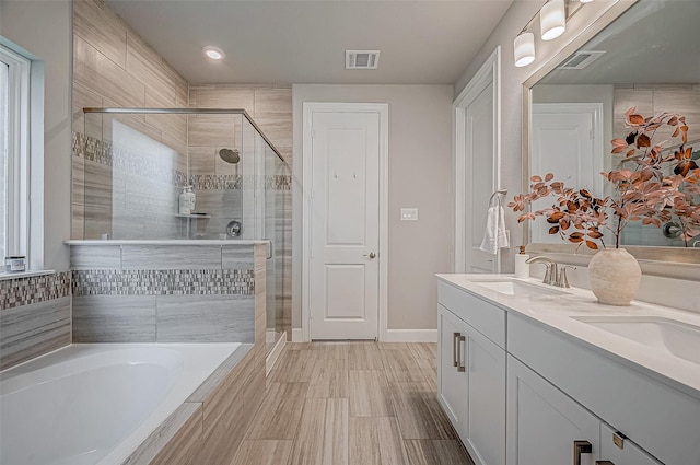 21450 Petherton Dr, Tomball, TX 77375 - full bathroom with a shower stall, a garden tub, double vanity, baseboards, and recessed lighting