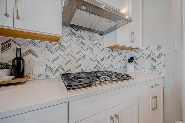 21450 Petherton Dr, Tomball, TX 77375 - kitchen featuring wall chimney range hood, stainless steel gas stovetop, decorative backsplash, white cabinets, and light countertops
