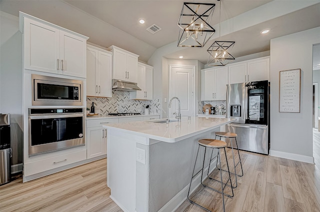 21450 Petherton Dr, Tomball, TX 77375 - kitchen with appliances with stainless steel finishes, a sink, decorative backsplash, light countertops, and under cabinet range hood