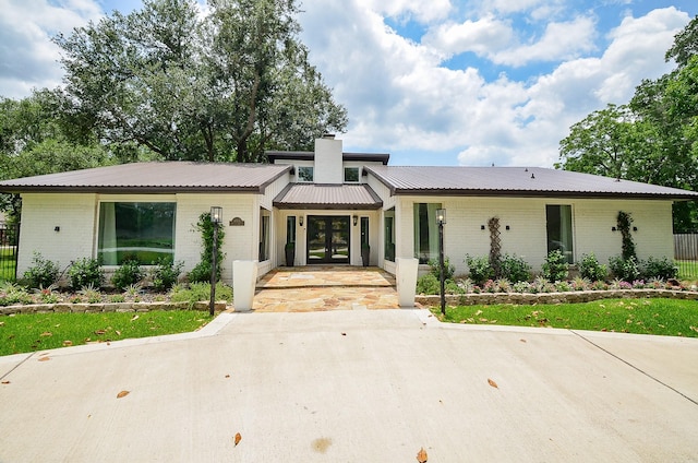 36615 Maverick Rd, Simonton, TX 77485 - mid-century home featuring french doors, brick siding, a chimney, and metal roof