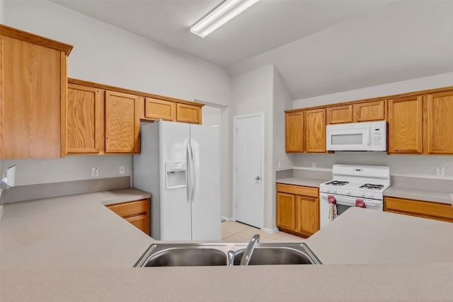 11823 Lois Ln, Pinehurst, TX 77362 - kitchen with white appliances, a sink, light countertops, vaulted ceiling, and light tile patterned floors