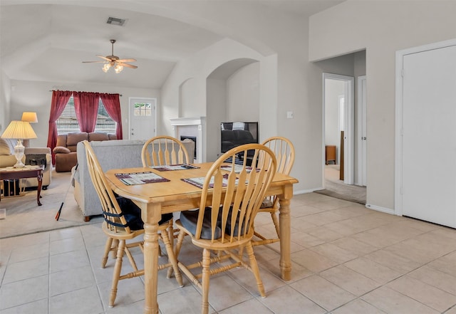 11823 Lois Ln, Pinehurst, TX 77362 - dining area featuring light tile patterned floors, ceiling fan, a fireplace, lofted ceiling, and arched walkways