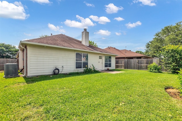 11823 Lois Ln, Pinehurst, TX 77362 - rear view of house featuring central air condition unit, a chimney, and roof with shingles
