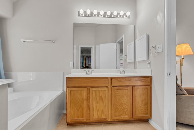 11823 Lois Ln, Pinehurst, TX 77362 - bathroom featuring double vanity, a bath, tile patterned floors, and baseboards