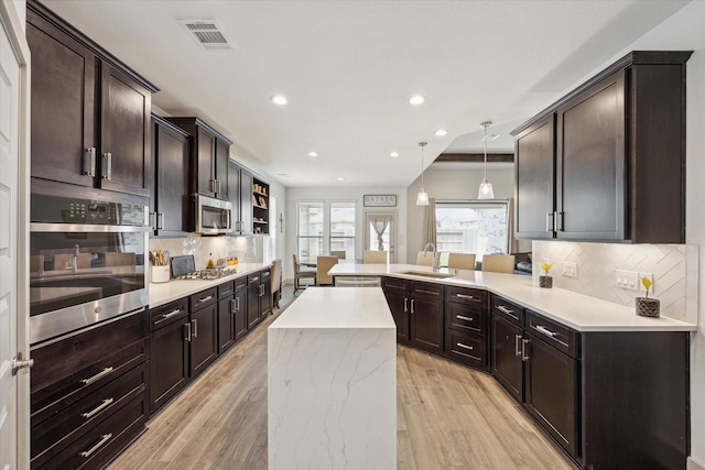 1685 Daylight Lake Dr, Katy, TX 77493 - kitchen featuring stainless steel appliances, a peninsula, a sink, decorative backsplash, and recessed lighting