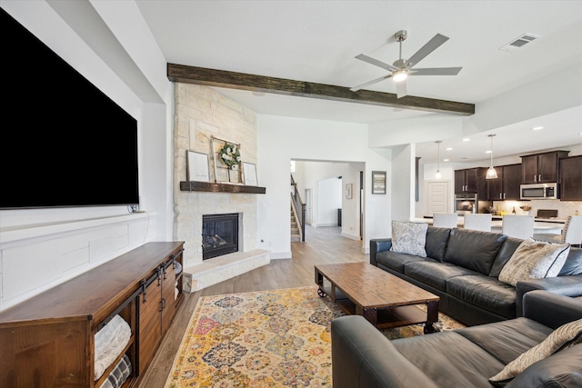 1685 Daylight Lake Dr, Katy, TX 77493 - living room featuring ceiling fan, light wood finished floors, beamed ceiling, a stone fireplace, and recessed lighting