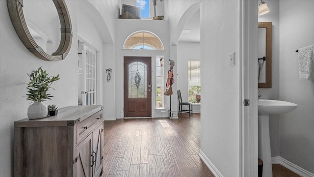 19603 Pitchstone Dr, Tomball, TX 77377 - entryway featuring healthy amount of natural light, dark wood-style floors, baseboards, and arched walkways