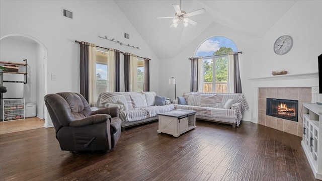 19603 Pitchstone Dr, Tomball, TX 77377 - living area with high vaulted ceiling, arched walkways, ceiling fan, a tile fireplace, and dark wood-style flooring