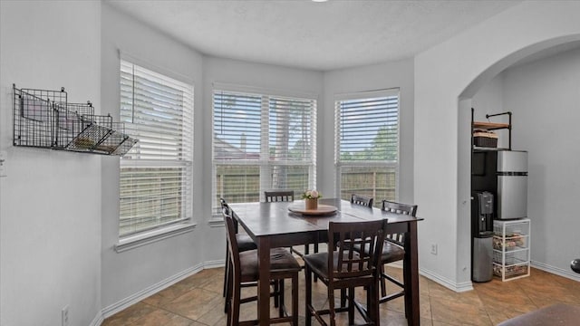 19603 Pitchstone Dr, Tomball, TX 77377 - tiled dining space featuring arched walkways and baseboards