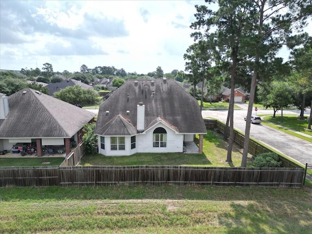 19603 Pitchstone Dr, Tomball, TX 77377 - back of house with a chimney and roof with shingles