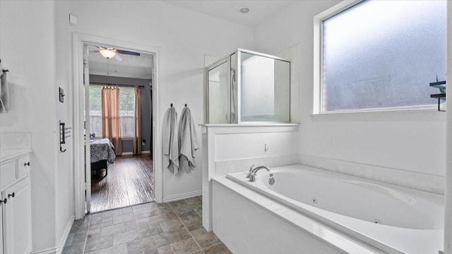 19603 Pitchstone Dr, Tomball, TX 77377 - ensuite bathroom with a shower stall, a jetted tub, ceiling fan, stone finish flooring, and baseboards