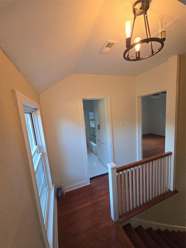 301 Harold St, Crockett, TX 75835 - hallway with a chandelier, wood finished floors, lofted ceiling, an upstairs landing, and baseboards