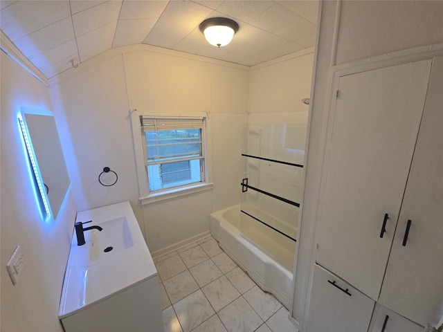 301 Harold St, Crockett, TX 75835 - full bathroom with lofted ceiling, marble look tiles, vanity, and tub / shower combination