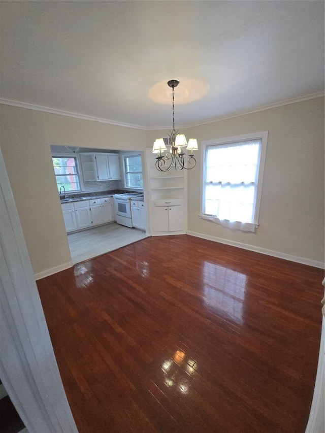 301 Harold St, Crockett, TX 75835 - unfurnished dining area with a chandelier, crown molding, wood finished floors, and baseboards
