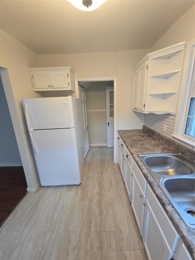 301 Harold St, Crockett, TX 75835 - kitchen with freestanding refrigerator, open shelves, white cabinets, and a sink