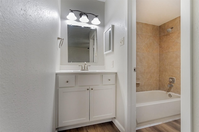 12626 Marble Dr, Houston, TX 77070 - bathroom featuring wood finished floors, vanity, bathtub / shower combination, and a textured wall