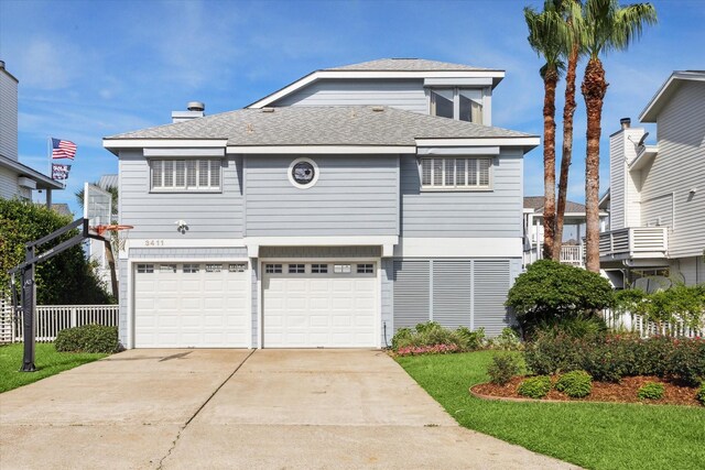 3411 Petite Cir, Galveston, TX 77554 - view of front of home featuring a garage, concrete driveway, and a shingled roof