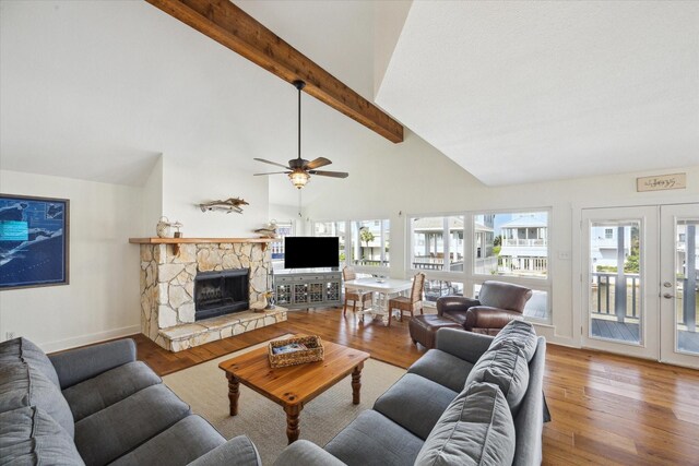 3411 Petite Cir, Galveston, TX 77554 - living area featuring beamed ceiling, wood finished floors, ceiling fan, high vaulted ceiling, and a stone fireplace