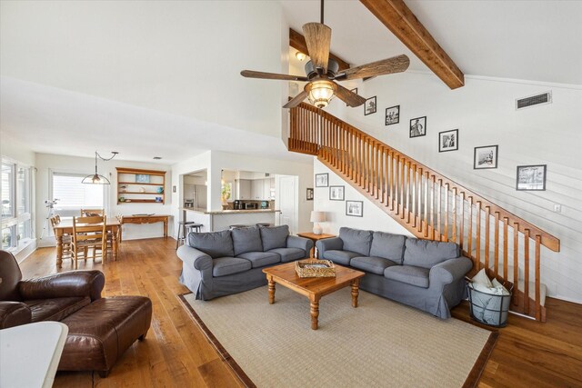 3411 Petite Cir, Galveston, TX 77554 - living room with hardwood / wood-style flooring, a ceiling fan, beam ceiling, stairway, and high vaulted ceiling