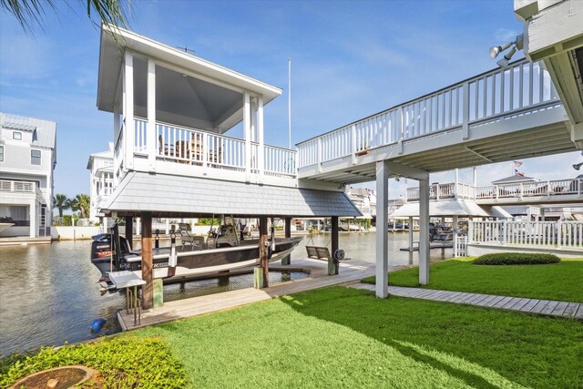 3411 Petite Cir, Galveston, TX 77554 - dock area featuring boat lift, a water view, and a lawn