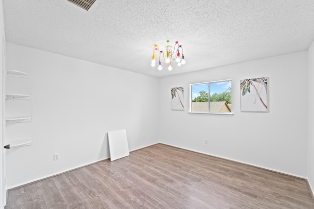16202 Pasadero Dr, Houston, TX 77083 - empty room with wood finished floors, a chandelier, and a textured ceiling