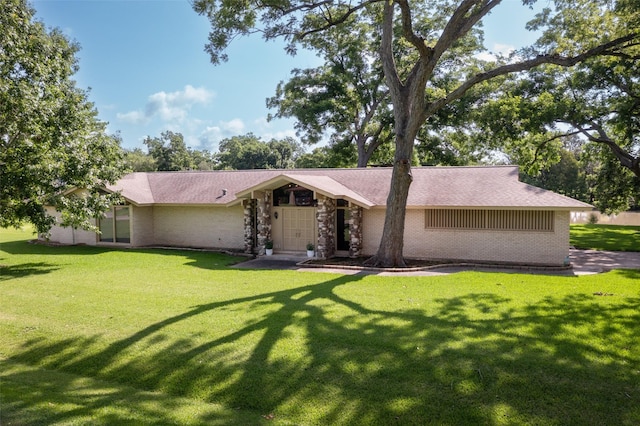 613 Bolling Green Dr, Wharton, TX 77488 - mid-century modern home featuring brick siding, a front yard, and roof with shingles