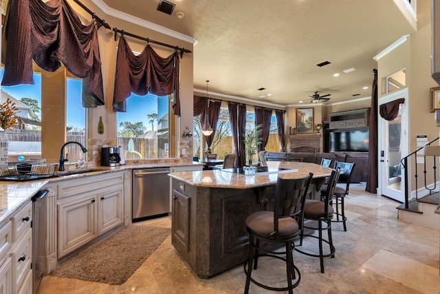 15818 Conners Ace Dr, Spring, TX 77379 - kitchen with dishwasher, ceiling fan, a center island, plenty of natural light, and ornamental molding