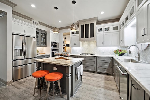 7 Woodstone St, Houston, TX 77024 - kitchen with appliances with stainless steel finishes, a sink, gray cabinetry, decorative backsplash, and light wood finished floors