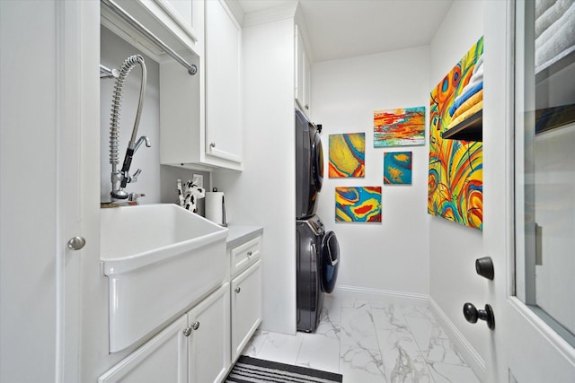 7 Woodstone St, Houston, TX 77024 - washroom with stacked washer / dryer, cabinet space, light marble finish flooring, and baseboards