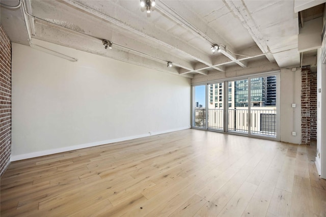 3600 Montrose Blvd Unit 906, Houston, TX 77006 - unfurnished room with brick wall, wood finished floors, beamed ceiling, and baseboards