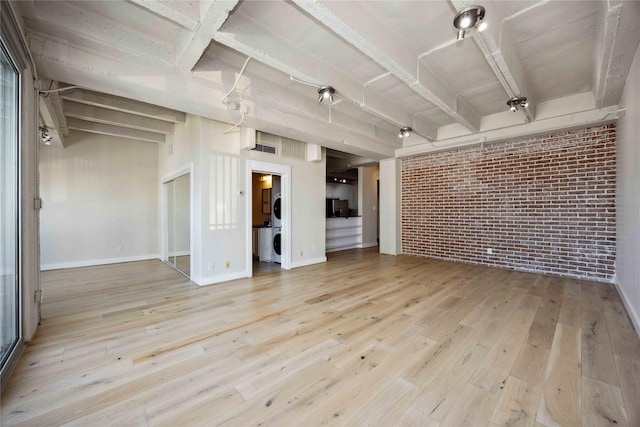 3600 Montrose Blvd Unit 906, Houston, TX 77006 - spare room featuring brick wall, hardwood / wood-style floors, baseboards, and washer / dryer