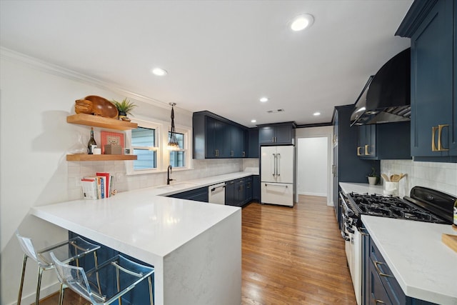 4509 Randwick Dr, Houston, TX 77092 - kitchen featuring built in fridge, gas range oven, exhaust hood, a peninsula, and backsplash