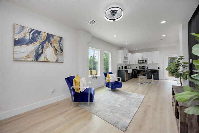 2114 Des Chaumes St, Houston, TX 77026 - living room with light wood-type flooring, recessed lighting, and baseboards