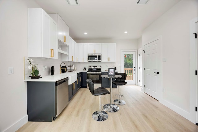2114 Des Chaumes St, Houston, TX 77026 - kitchen with stainless steel appliances, light wood finished floors, white cabinets, light countertops, and recessed lighting