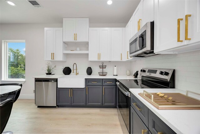 2114 Des Chaumes St, Houston, TX 77026 - kitchen with appliances with stainless steel finishes, a sink, white cabinets, and recessed lighting