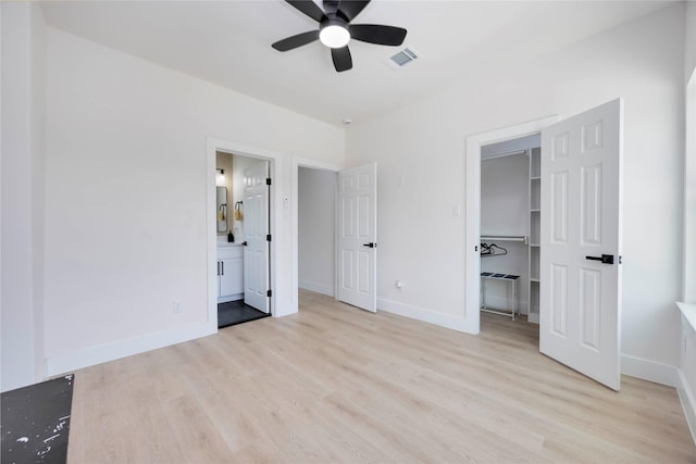 2114 Des Chaumes St, Houston, TX 77026 - unfurnished bedroom featuring light wood-style flooring, a spacious closet, baseboards, and connected bathroom