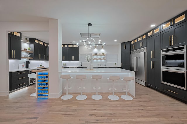 4434 Sarong Dr, Houston, TX 77096 - kitchen with open shelves, stainless steel appliances, light wood-style flooring, a breakfast bar, and light countertops